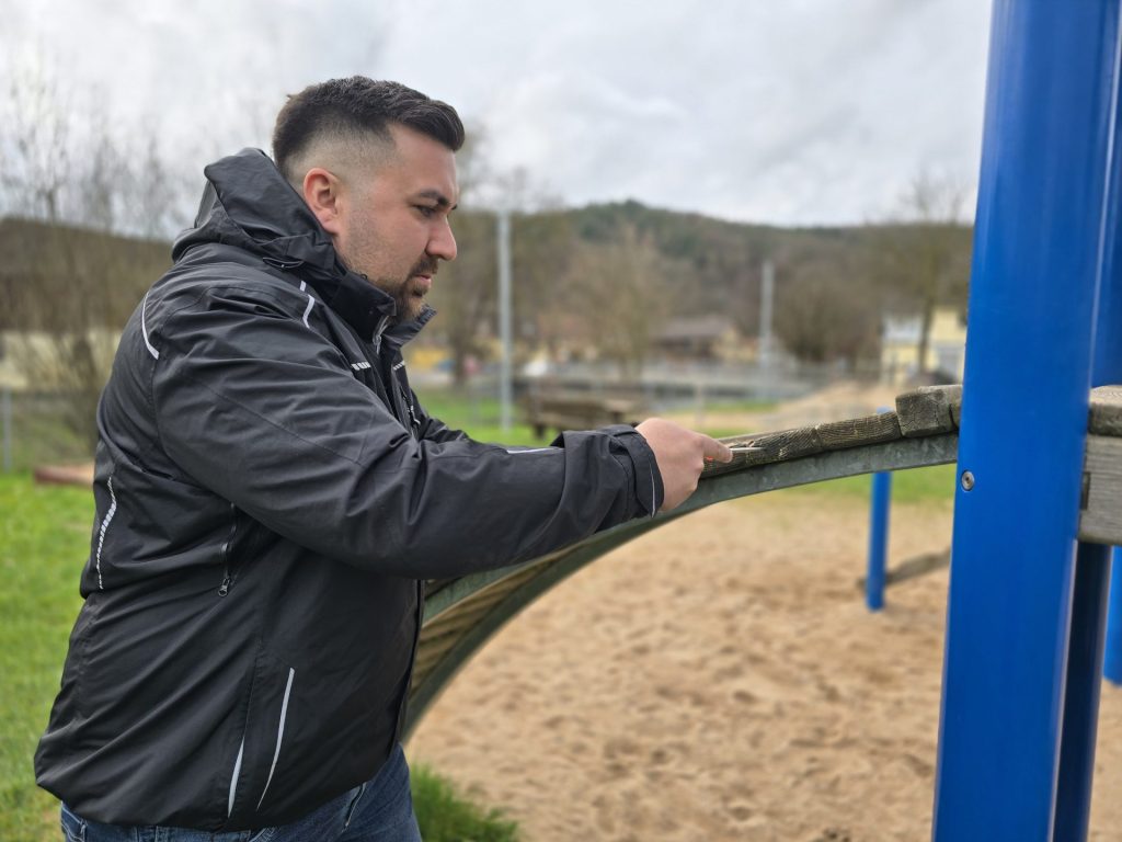 Mann auf Spielplatz mit Rutsche